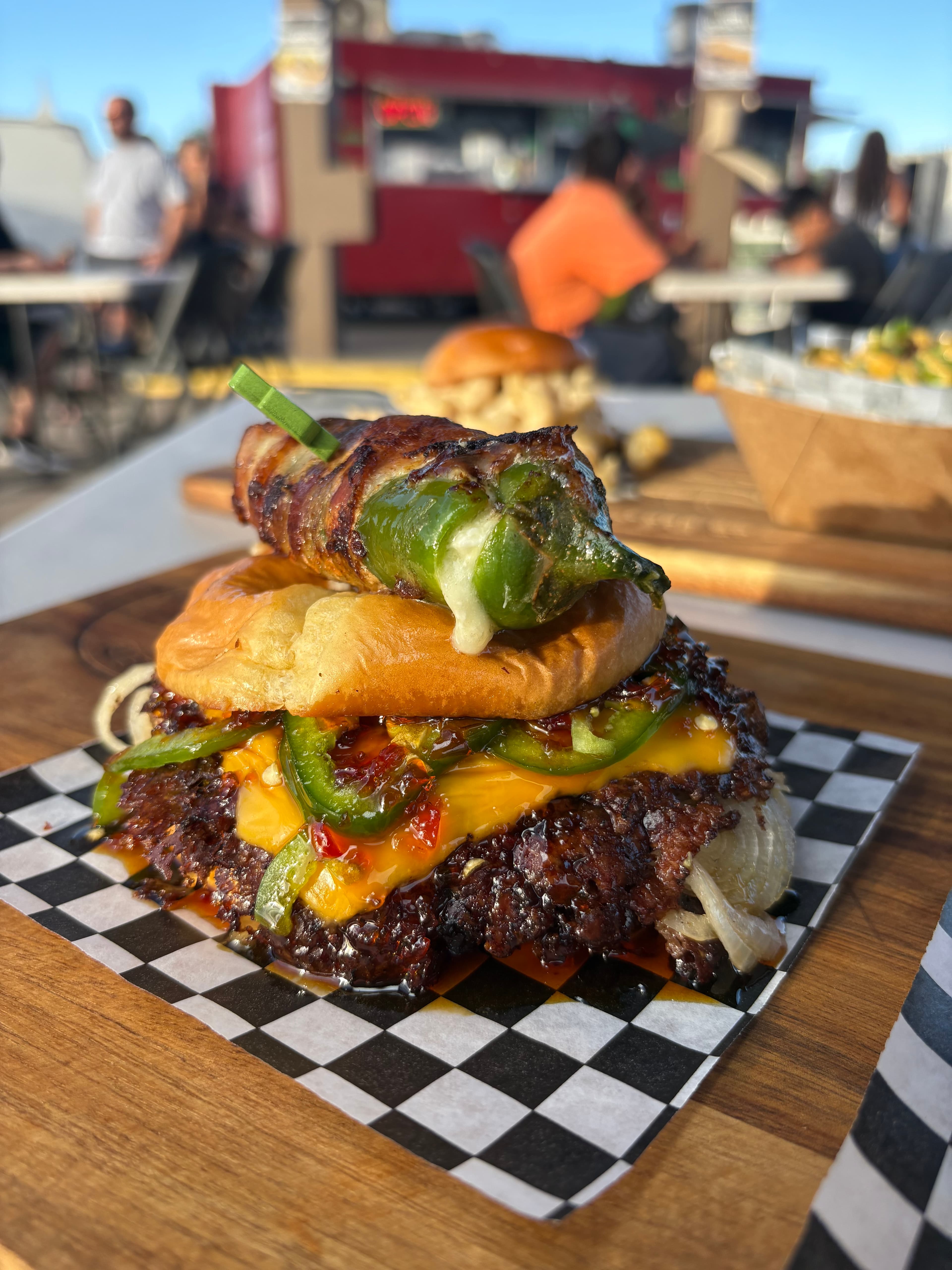 Bacon-wrapped jalapeño burger with caramelized onions and melted cheese